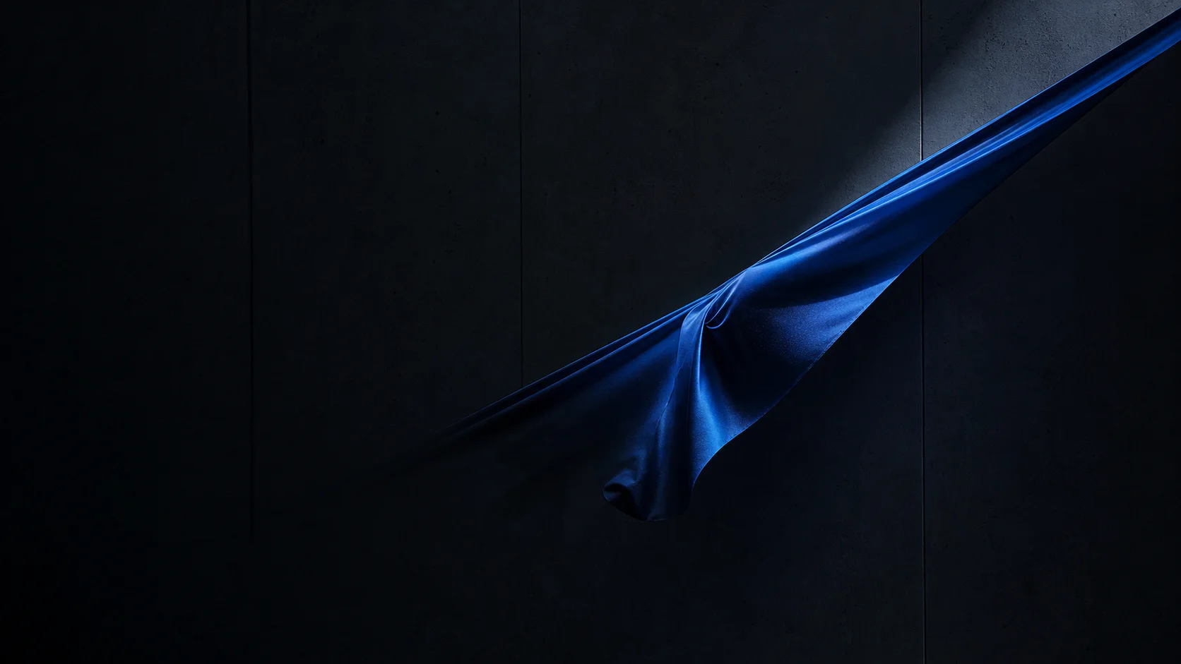 Cobalt technical fabric held in a precise diagonal gesture under cool light
